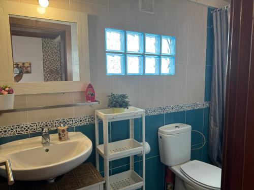 Un baño con lavabo, inodoro y espejo. en casa Valentina, en Playa Blanca