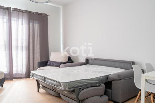Bett in einem weißen Zimmer mit Sofa in der Unterkunft Koti Rentals - Azarbe in Santa Fe de los Boliches
