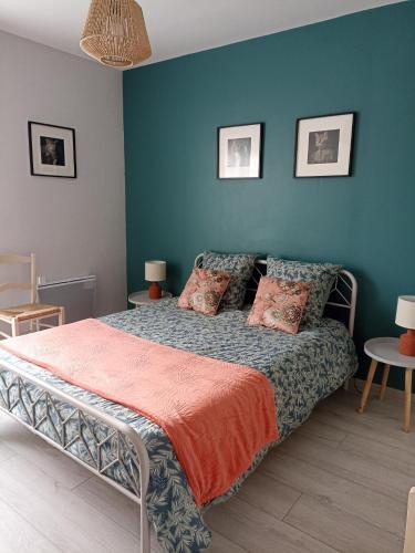 une chambre avec un lit avec un mur bleu dans l'établissement Entre 2 Châteaux, à Onzain