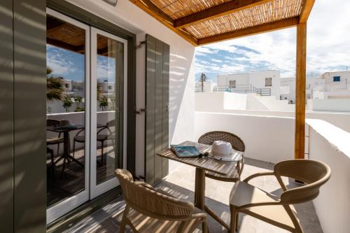 a balcony with chairs and a table on a balcony at Sea & Sun Paros in Naousa