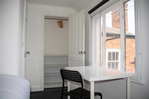 a bedroom with a white table and a window at 6 BR 4 Bath Central Worcester Sleeps 12 in Worcester