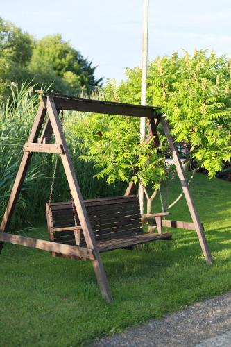 a wooden swing in the grass in a yard at Angelina 13 in Bosau
