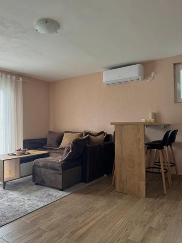 a living room with a couch and a table at Lakeside Harmony Apartment in Golubovci