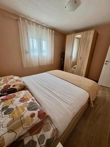 a bedroom with two beds and a window at Lakeside Harmony Apartment in Golubovci