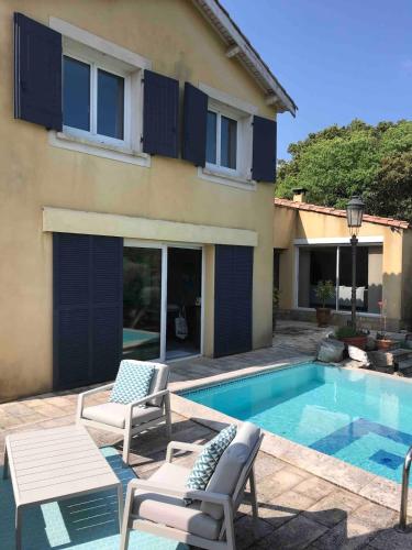 une villa avec une piscine, 2 chaises et une maison dans l'établissement Jolie Maison méditerranéenne, à Teyran