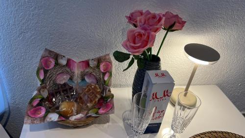 a vase of roses and a box of chocolates on a table at Zum Sterngässchen in Ludwigshafen am Rhein