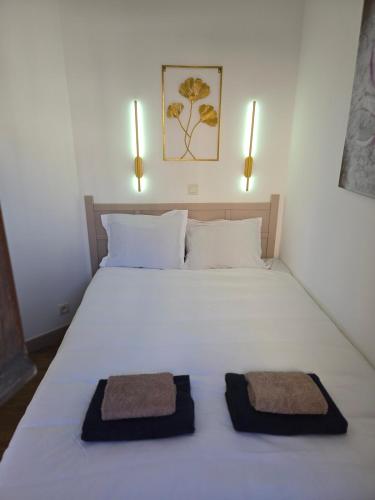 une chambre avec un lit blanc avec deux serviettes dessus dans l'établissement RENOIR 1265 Villa Francia - F2 très belle vue mer, à Cannes