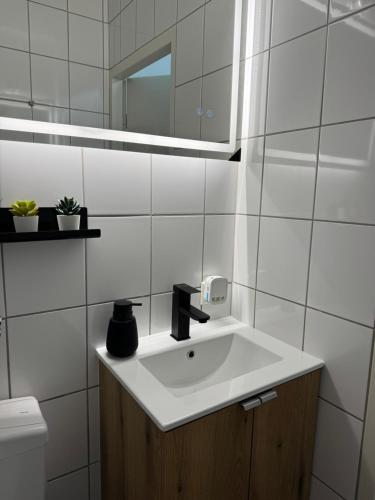 a white bathroom with a sink and a mirror at Peak11 Fewo- Panorama View Lahnstein Pool & Sauna in Lahnstein
