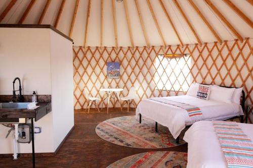 a yurt with two beds and a table in it at Johnny Yurts - The Pearl in Johnson City
