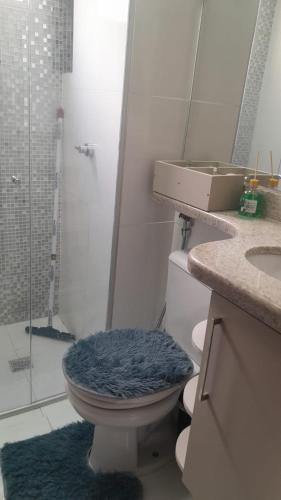 a bathroom with a toilet with a blue rug at AP ALPHA 5 STAr in Vespasiano