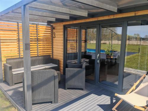 a pergola with a table and chairs on a deck at Domki RELAXO Rewal in Rewal