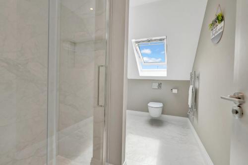 a white bathroom with a shower and a toilet at Travard at Heathrow 386 in Harmondsworth