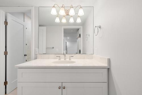 ein weißes Badezimmer mit Waschbecken und Spiegel in der Unterkunft 1351 Fairway Oaks Villa by Akers Ellis Rentals in Kiawah Island