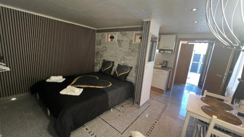 a bedroom with a black bed and a table and chairs at Zum Sterngässchen in Ludwigshafen am Rhein