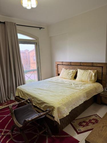 a bedroom with a large bed and a window at ڤيلا بجاردن في كومبوند لاڤيستا توباز العين السخنه in Ain Sokhna