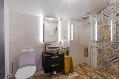 a bathroom with a sink and a toilet and a shower at Laxå Herrgårdshotellet in Laxå