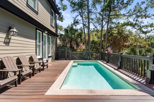 a deck with a pool and chairs on a house at 14 Angler Hall by Akers Ellis Rentals in Kiawah Island