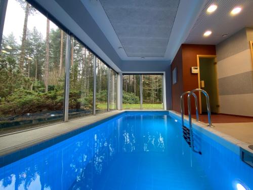 a swimming pool with a large window in a house at Kakumäe Raba Villa - puhkemaja basseiniga Tallinnas in Tallinn