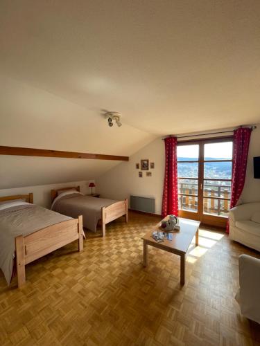 Un dormitorio con una cama, un sofá y una mesa. en Les Hauts du Lac, en Gérardmer
