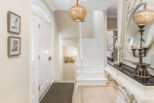 un corridoio con scale bianche e specchio di 16 Ocean Green Drive by Akers Ellis Rentals a Kiawah Island