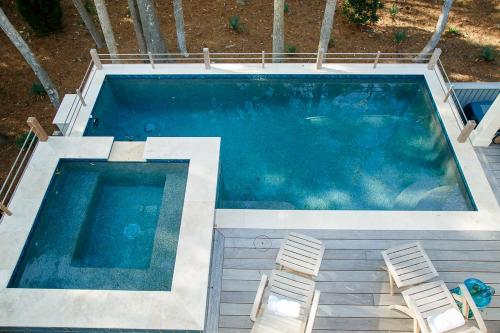 an overhead view of a swimming pool with two chairs at 165 Surfsong Road by Akers Ellis Rentals in Kiawah Island