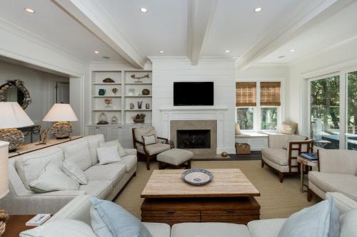 a living room with white furniture and a fireplace at 165 Surfsong Road by Akers Ellis Rentals in Kiawah Island