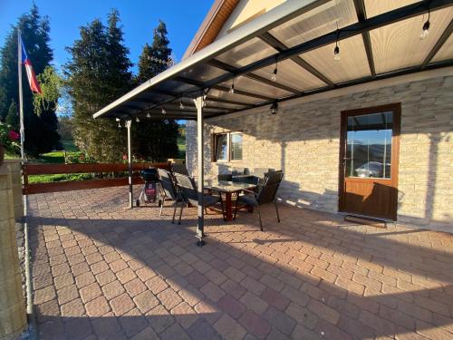 a patio with a table and chairs under a roof at FoRest in Bystrzyca