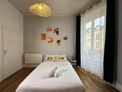 une chambre avec deux lits et une grande fenêtre dans l'établissement Le Charme d'Antan, hyper center, au Mans