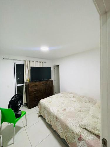 sypialnia z łóżkiem i telewizorem z płaskim ekranem w obiekcie Aluguel de Apartamento em Cabo Frio Temporada e Finais de Semana w mieście Cabo Frio