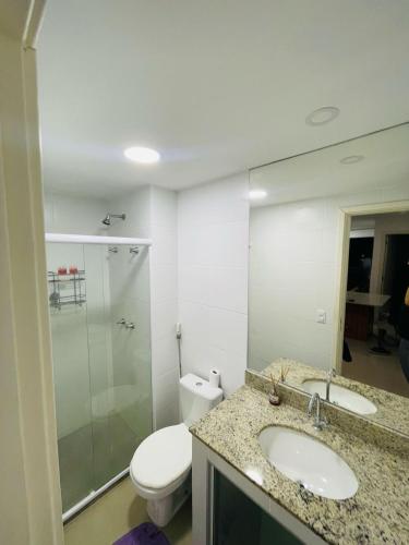 łazienka z toaletą, umywalką i lustrem w obiekcie Aluguel de Apartamento em Cabo Frio Temporada e Finais de Semana w mieście Cabo Frio