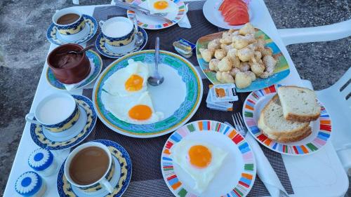 a table with eggs and biscuits and cups of coffee at Rooms to let Spiropali in Piqeras