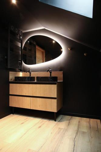 une salle de bain avec un lavabo et un miroir dans l'établissement Détente à deux piscine et spa, à Fêche-lʼÉglise