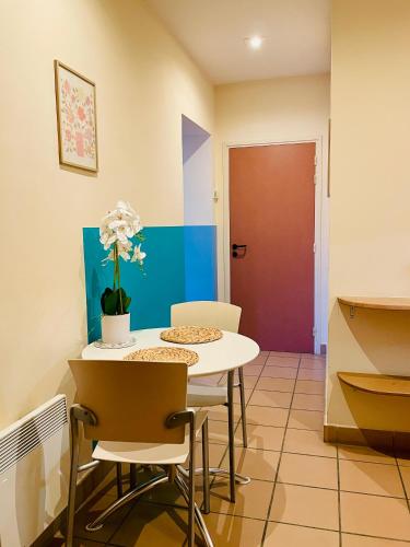 a room with a table and chairs and a door at Appart'Hôtel - Au Vieux Palais in Espalion