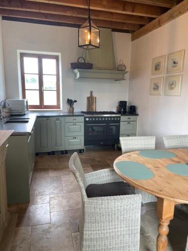 a kitchen with a table and some chairs and a table at Gite de Fleur - Chateau du Grand Luçay in Bourbon-lʼArchambault