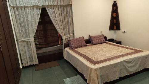 a small bedroom with a bed and a window at Maleyam Homestay Riverside in Kozhikode