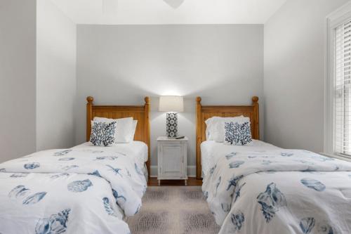 two beds in a room with white walls at 216 Glen Abbey by Akers Ellis Rentals in Kiawah Island