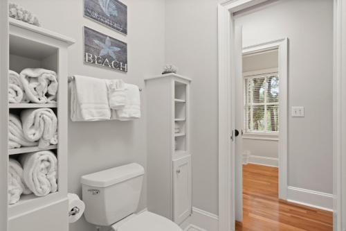 a white bathroom with a toilet and towels at 216 Glen Abbey by Akers Ellis Rentals in Kiawah Island