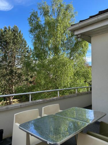 a glass table and chairs on a balcony at La Chambre de Marie in Bouxwiller