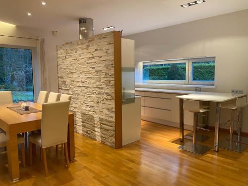 a kitchen and dining room with a stone wall at Kakumäe Raba Villa - puhkemaja basseiniga Tallinnas in Tallinn