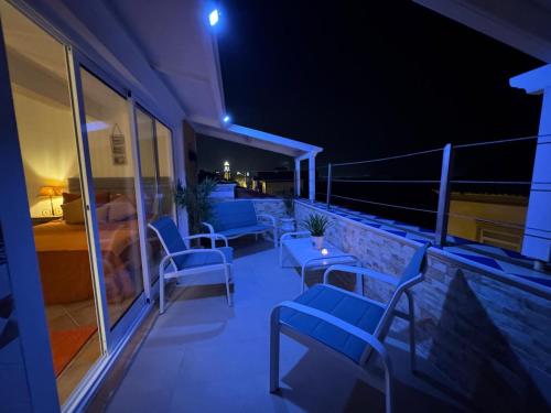 un balcone con sedie blu su un edificio di notte di Residência Bavaria, espaço inteiro no centro de Ponta Delgada a Ponta Delgada