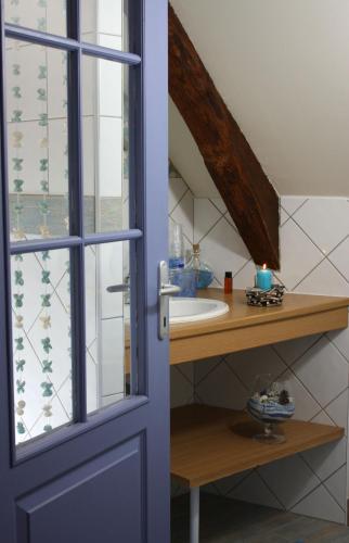 a bathroom with a sink and a mirror at Les Keriaden's in Pleudihen