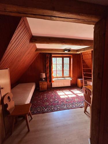 an attic room with a bed and a window at Dom pod Cuplikiem in Zawoja