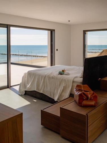 une chambre avec un lit et une vue sur la plage dans l'établissement La villa de la plage, à Mauguio