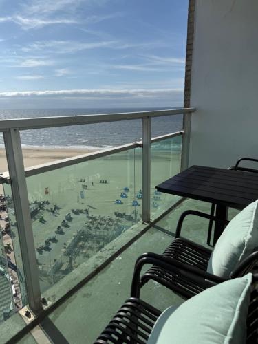 een balkon met uitzicht op het strand en de oceaan bij Sunset Beach in Zandvoort
