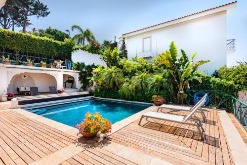 a swimming pool with a chair and a house at Mbird Estoril Riviera Flat 3 in Estoril