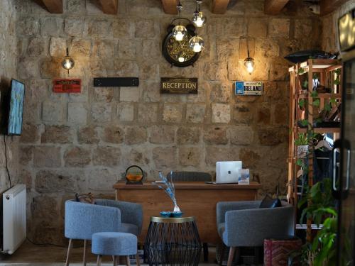 a room with a stone wall with chairs and a counter at Mayda Cappadocia in Uchisar