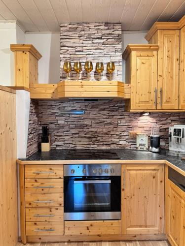 a kitchen with wooden cabinets and a blue oven at Ferienwohnung-Mixnitz-Bärenschützklamm 3 in Mixnitz