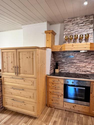 a kitchen with wooden cabinets and a microwave at Ferienwohnung-Mixnitz-Bärenschützklamm 3 in Mixnitz