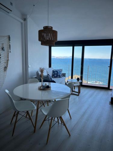a living room with a table and chairs and a couch at Sa Calma - Cap Sa Sal Begur in Isla Negra