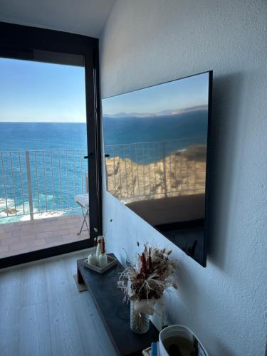 a bathroom with a large mirror and a view of the ocean at Sa Calma - Cap Sa Sal Begur in Isla Negra